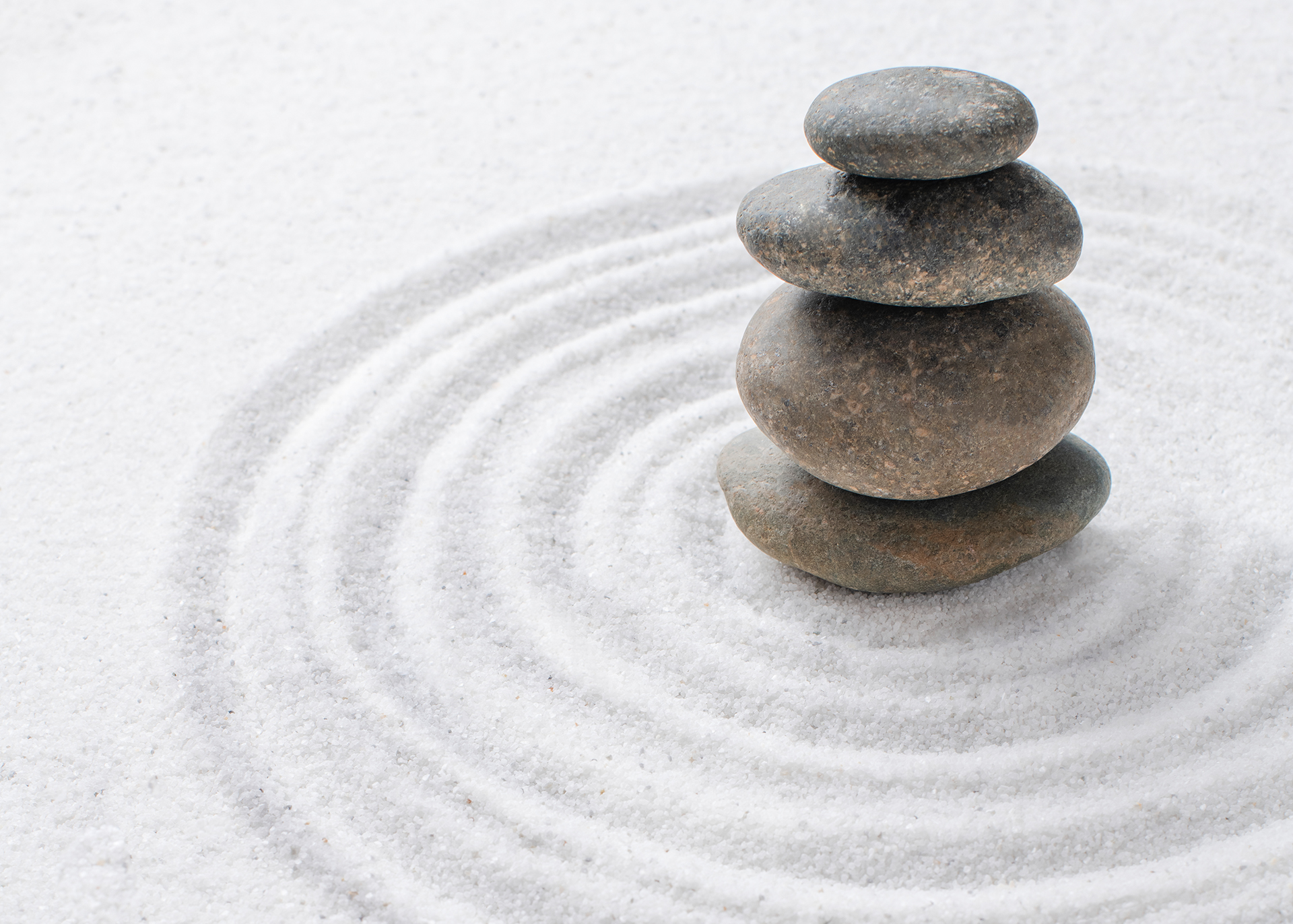 Steine aufgetürmt auf Sand - Hypnose