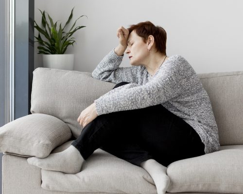 Frau auf Sofa - Psychosomatische Belastung